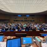 Sala com pessoas sentadas emn negociações. monitores de computadores