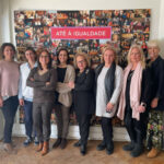 8 mulheres lado a lado posam para foto. por trás, painel de fotografias várias e o título até à igualdade.