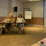 Mesa com 3 pessoas. Projeção de slide