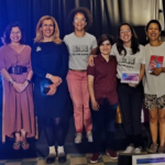 8 mulheres em pé, 2 das quais segurando as brochuras Lés Saúde