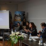 Mesa de conferência com a Presidente da CIG a discursar