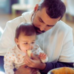 Homem a dar banana a bebé