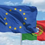 bandeira de portugal e união europeia desfraldadas ao vento sobre um céu azul com nuvens brancas